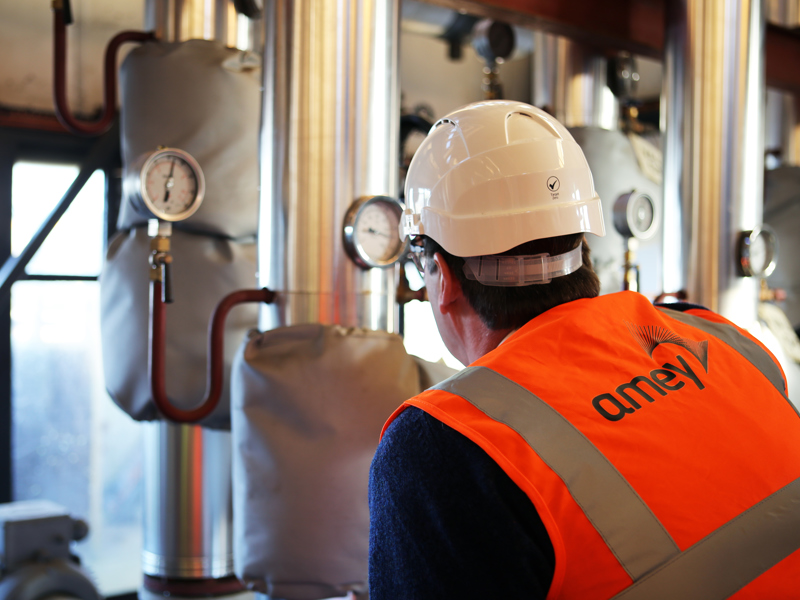 Man in PPE, working in a boiler room.