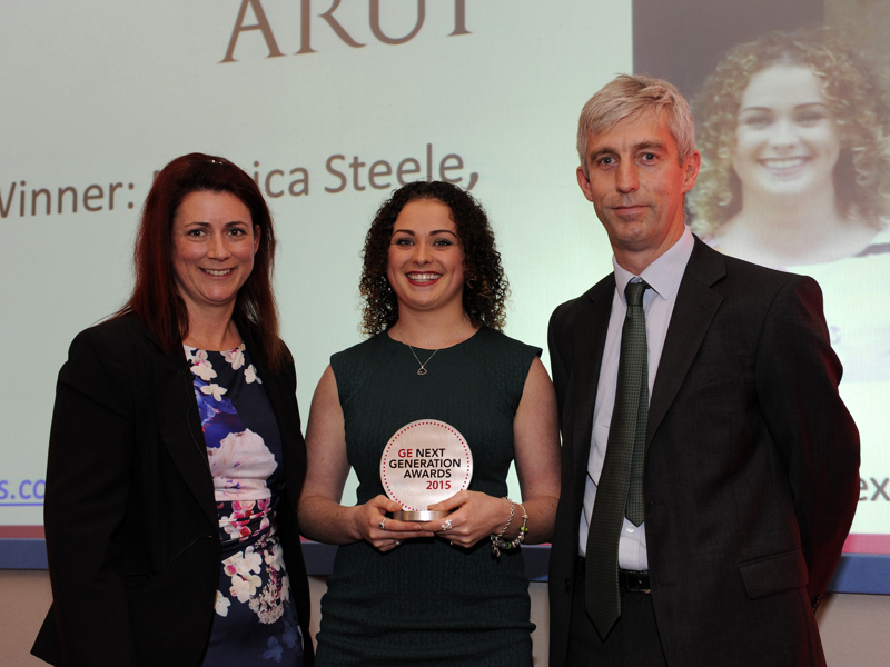 A group of Amey employees, in formal attire, holding an award.
