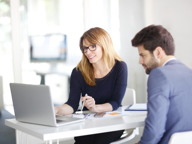 A man and women sharing a laptop screen.